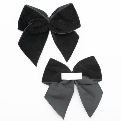 Front and back of black 10cm velvet bows showing the self-adhesive strip