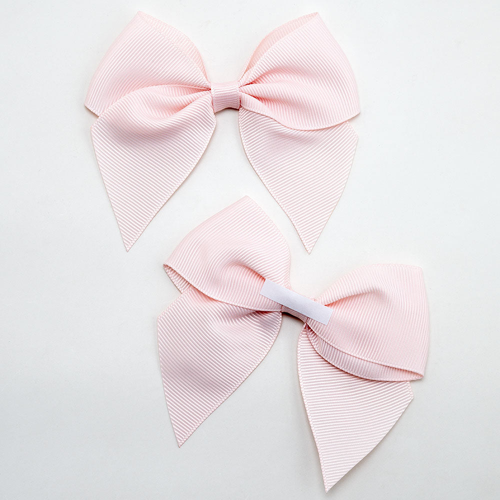 Front and back of blush pink 10cm grosgrain bow showing the self-adhesive strip