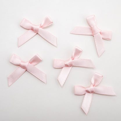 Packaged blush pink mini satin ribbon bows for crafts and wedding stationery