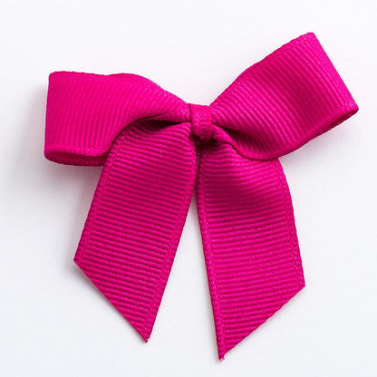 Cerise 5cm self-adhesive grosgrain ribbon bow on a white background