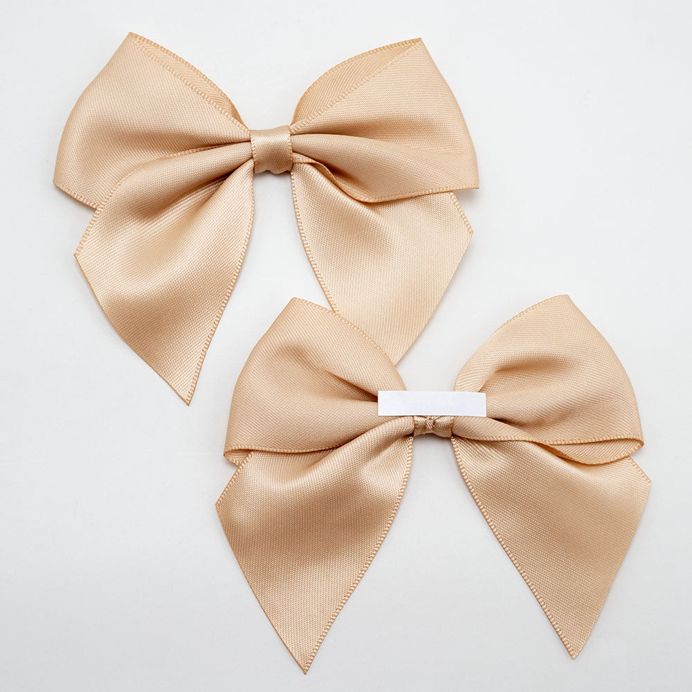 Front and back of champagne gold 10cm satin gift bows showing the adhesive strip