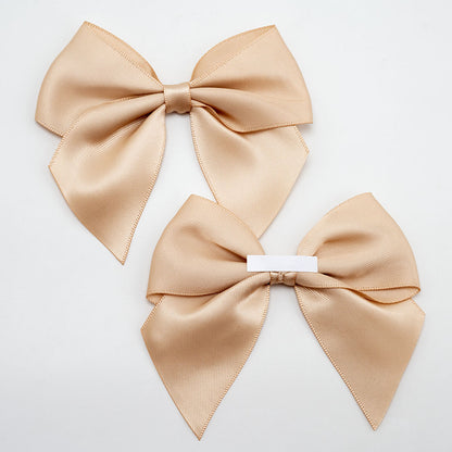 Front and back of champagne gold 10cm satin gift bows showing the adhesive strip