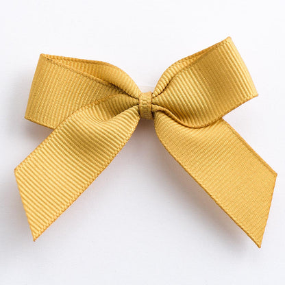 Gold 5cm self-adhesive grosgrain ribbon bow on a white background