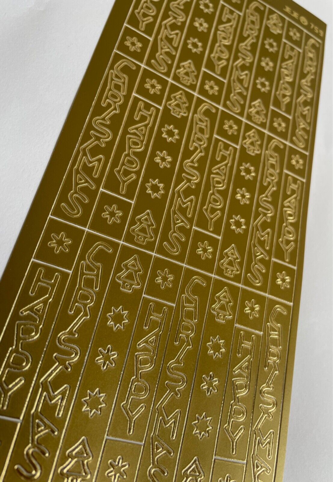 Close-up of gold Happy Christmas peel off greetings for card making