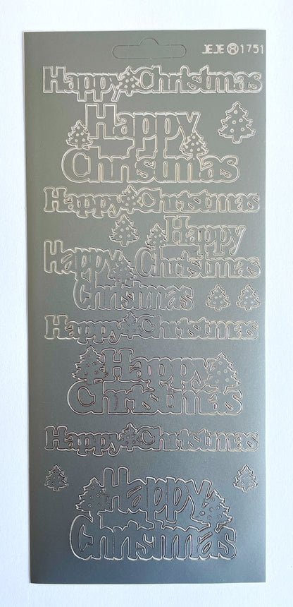 A sticker sheet of Christmas-themed greetings including 'Happy Christmas' phrases and small tree motifs, shown against a plain white background.