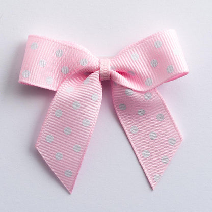 Pink 5cm polka dot grosgrain ribbon bow on a white background