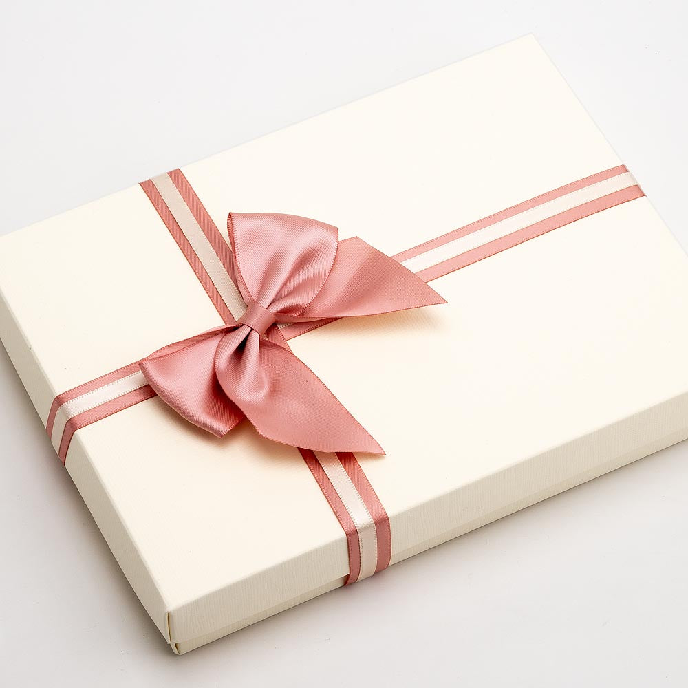 Rose gold large satin gift bow decorating a wrapped present