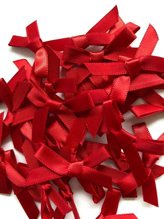 Close up of ruby red pre tied 3cm satin ribbon bows in 100 pack for wedding stationery and favours