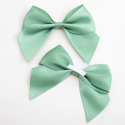 Front and back of sage green 10cm satin gift bows showing the adhesive strip