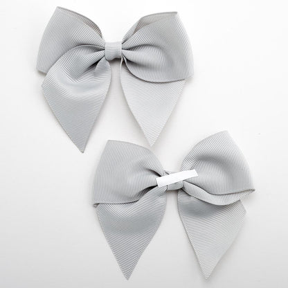 Front and back of silver 10cm grosgrain bow showing the self-adhesive strip