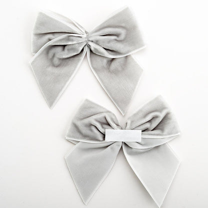 Front and back of silver 10cm velvet bows showing the self-adhesive strip