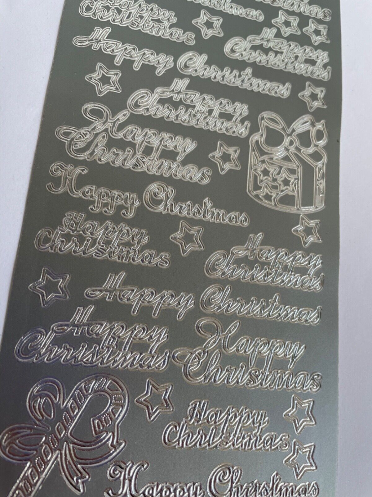 Close-up of silver Happy Christmas peel off greetings for handmade card