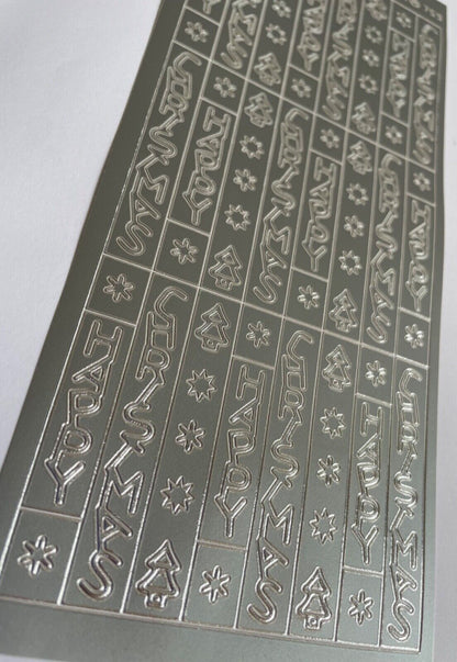Close-up of silver vertical Happy Christmas peel off stickers with trees and stars