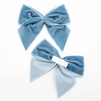 Front and back of vintage blue 10cm velvet bows showing the self-adhesive strip