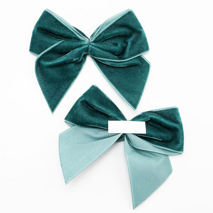 Front and back of vintage teal 10cm velvet bows showing the self-adhesive strip