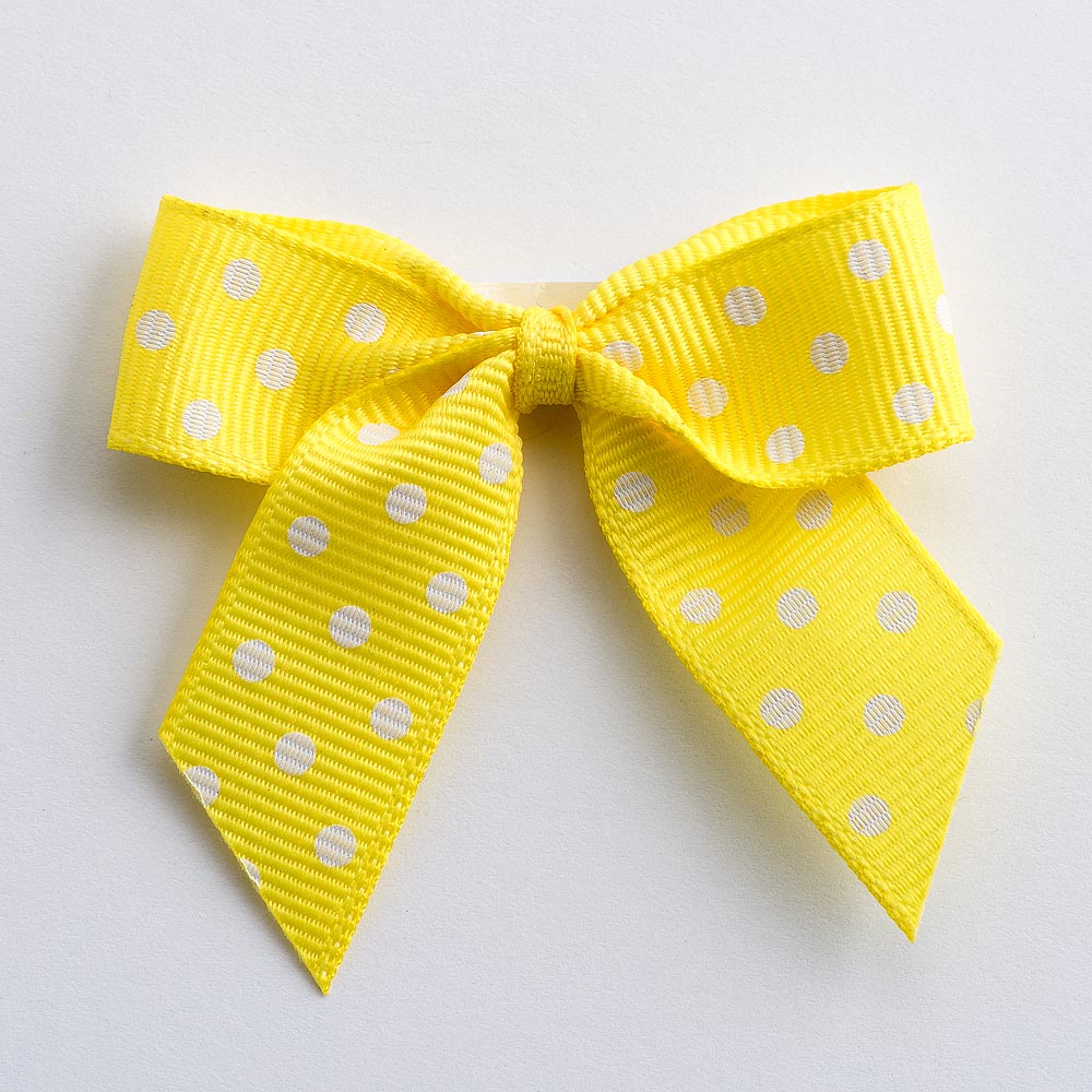 Yellow 5cm polka dot grosgrain ribbon bow on a white background