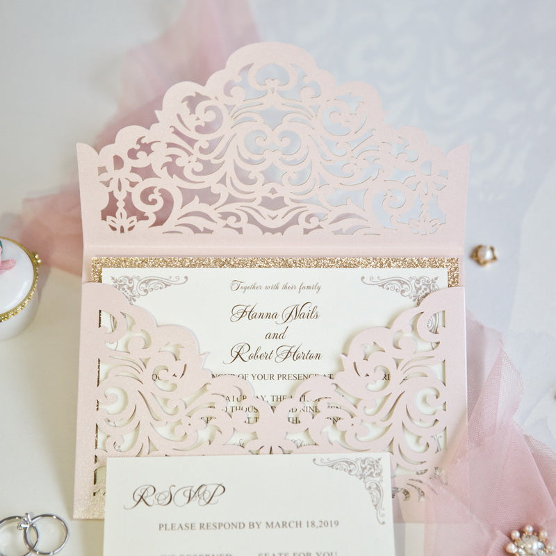 Close up of gold glitter and pale pink laser cut lace style envelope pocket wedding invites