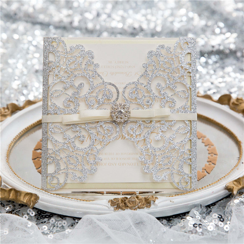 silver glitter wedding invitation on decorative plate on wedding table setting