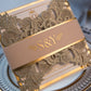 Close up of gold foil printed belly band around a glitter gold gatefold wedding invitation